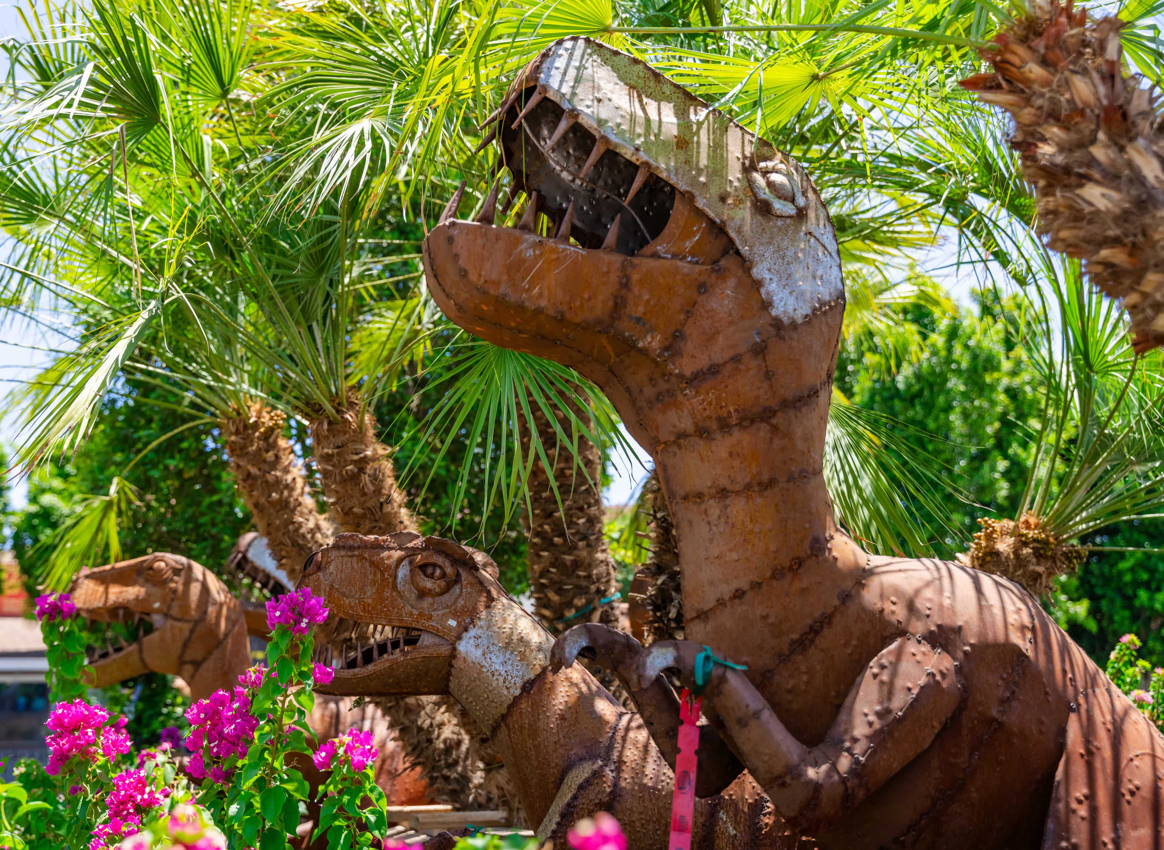 Dinosaur metal statues and decor at a Nursery location.